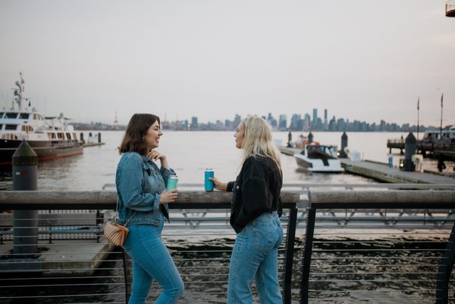 women having drinks on pier